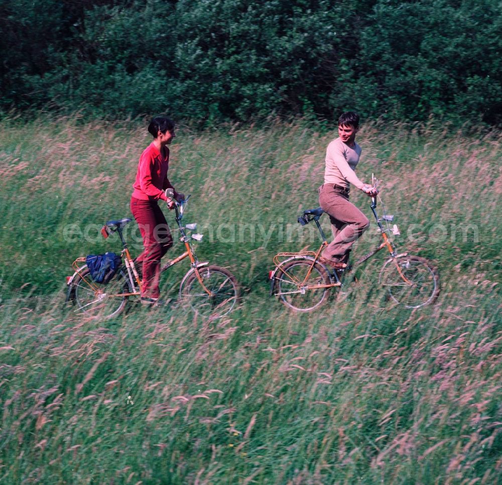 GDR picture archive: Hohen Neuendorf - Young couple on folding bikes on the road in the countryside in Hohen Neuendorf in Brandenburg today