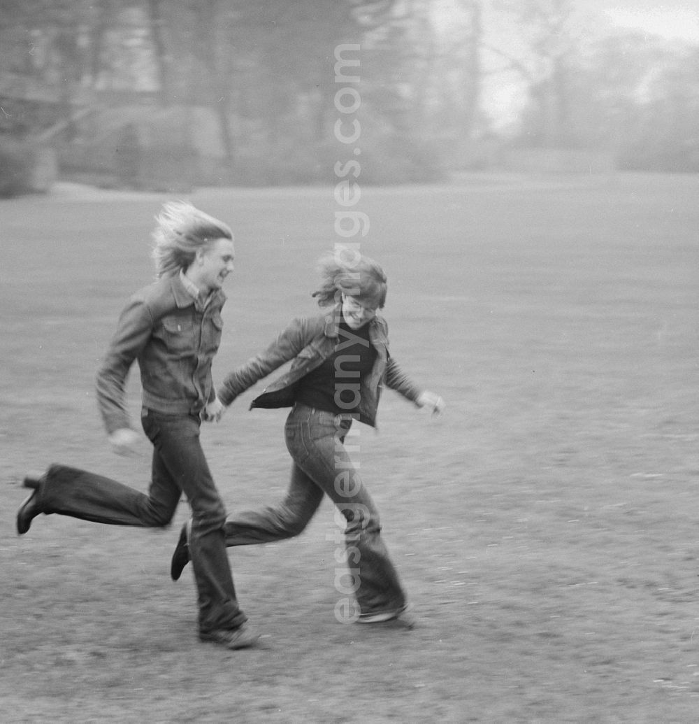 GDR image archive: Berlin - Young couple running through a meadow in Berlin