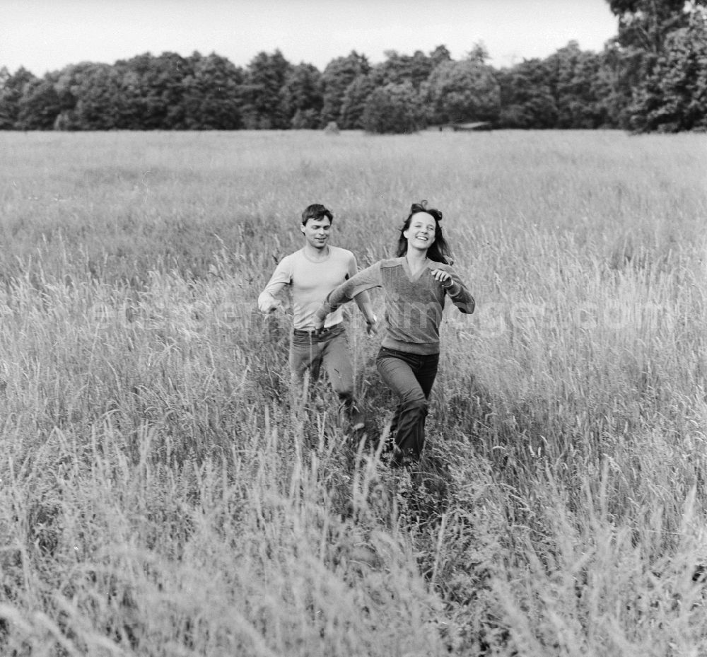 Hohen Neuendorf: Young couple running through a meadow in Hohen Neuendorf in Brandenburg today