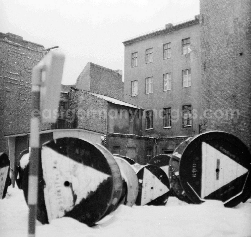 Berlin: In a backyard cable drums of the KWO, cable work VEB Oberspree, in the snow lie in Berlin, the former capital of the GDR, German democratic republic