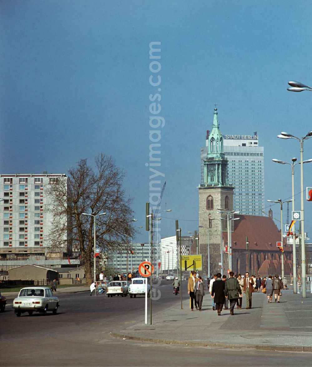 Berlin: Passanten laufen entlang der Karl-Liebknecht-Straße in Berlin. Im Hintergrund die Marienkirche, umgeben von den gerade neu errichteten Neubauten sozialistischer Architektur. Links im Bild fehlt noch das Palasthotel. Dieser Hotelkomplex an der Spree wurde erst in der Zeit zwischen 1976 bis 1979 errichtet.