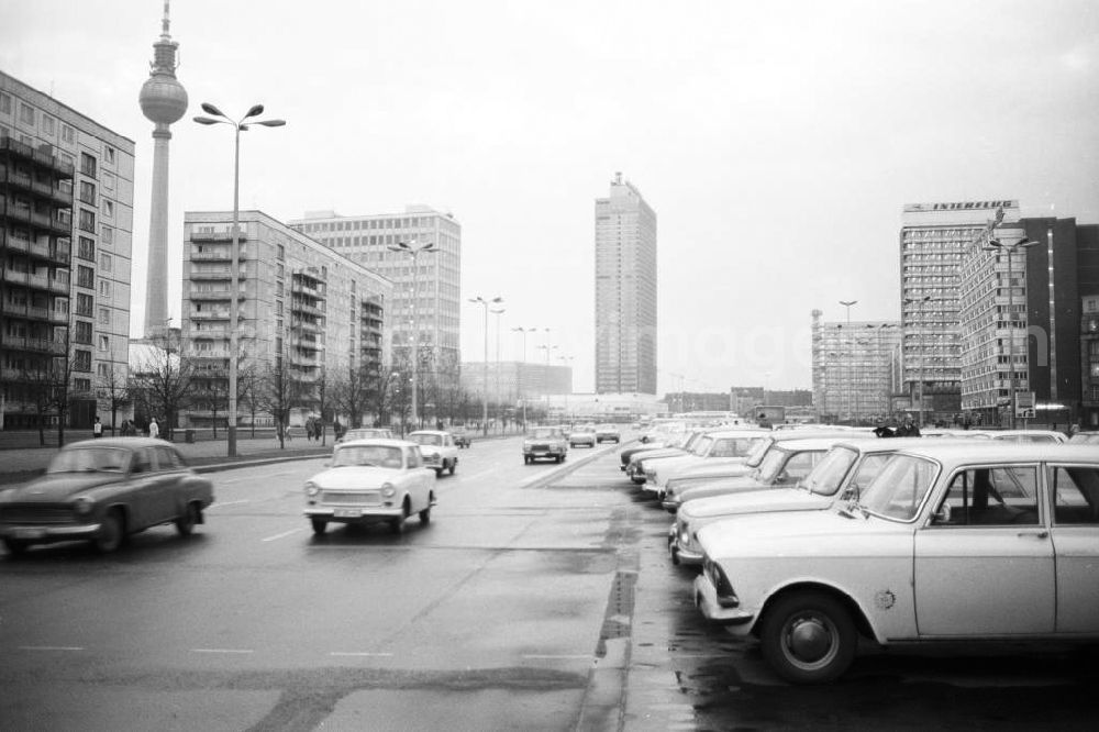 GDR photo archive: Berlin - Blick auf die Karl-Marx-Allee, Autos fahren auf Strasse (u.a. Trabant), im Hintergrund das Hotel Stadt Berlin und der Berliner Fernsehturm. Autos stehen auf Parkplatz u.a. Moskwitsch.