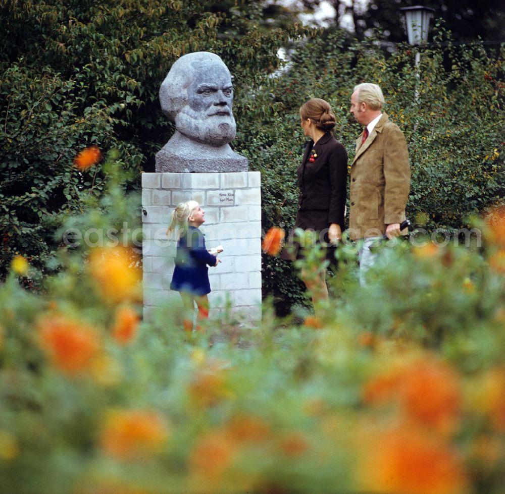 GDR picture archive: Berlin - Eine Familie geht bei ihrem Spaziergang an einer Karl-Marx-Büste des Künstlers Hans Kies vorbei.
