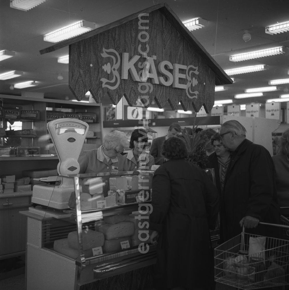GDR picture archive: Berlin - Kaufhalle in Lichtenberg/ Dolgenseestrasse. Der gut sortierte Käsestand der HO-Verkaufstelle mit Kunden und Verkäuferinnen.