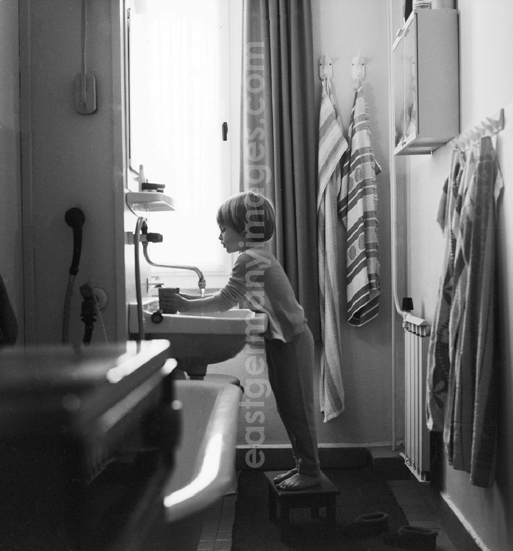 GDR image archive: Berlin - Child while brushing your teeth in a newly built bathroom with central heating in Berlin, the former capital of the GDR, the German Democratic Republic