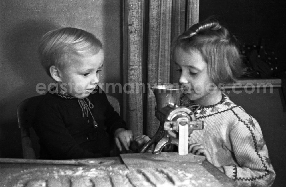 GDR picture archive: Merseburg - Children with the little place bake in the kitchen in Merseburg in the federal state Saxony-Anhalt in Germany