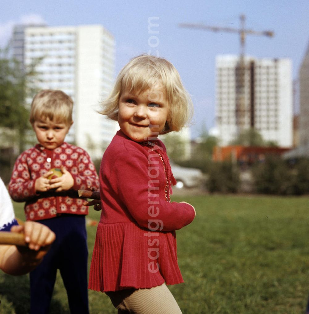 GDR photo archive: Berlin - Kinder spielen auf einer grünen Wiese in einem gerade errichteten Neubauviertel in Berlin.