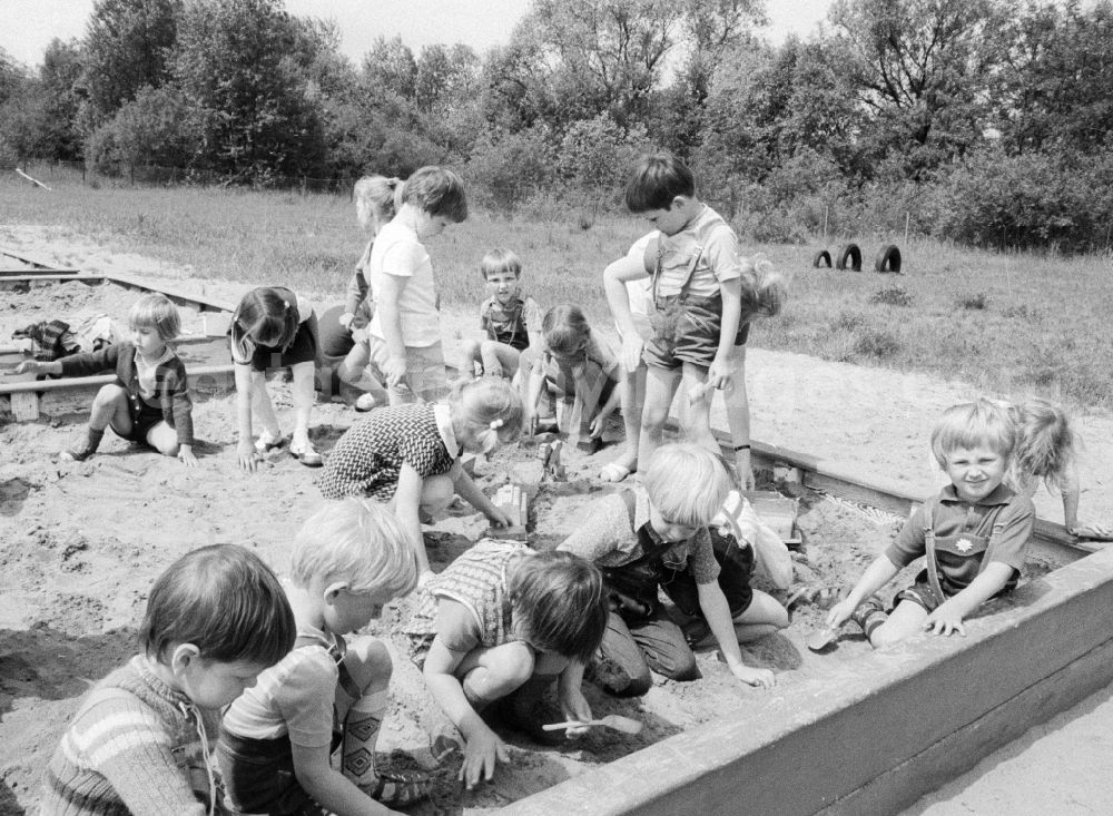 Eberswalde: Children in day care center of VEB mill Finow playing outside in the sand box in Eberswalde in Brandenburg on the territory of the former GDR, German Democratic Republic