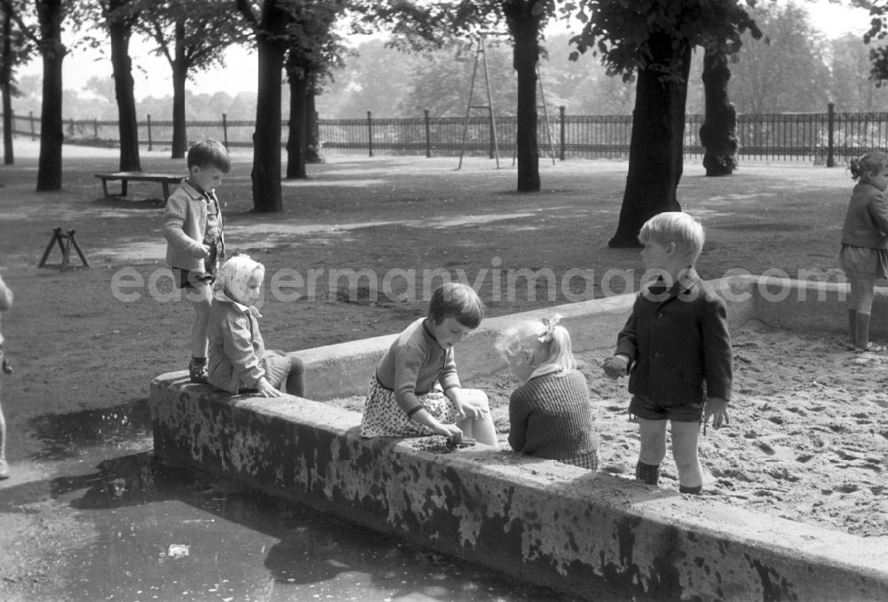 GDR picture archive: Magdeburg - Children playing in the sandbox on a playground in Magdeburg