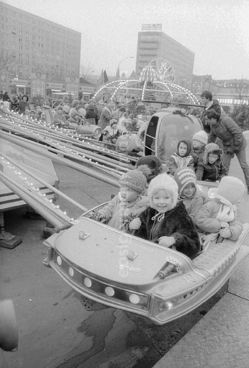 Berlin: Children sit in a roundabout on the Berlin Christmas fair in Berlin, the former capital of the GDR, German democratic republic. Today there stands at this point the shopping centre Alexa