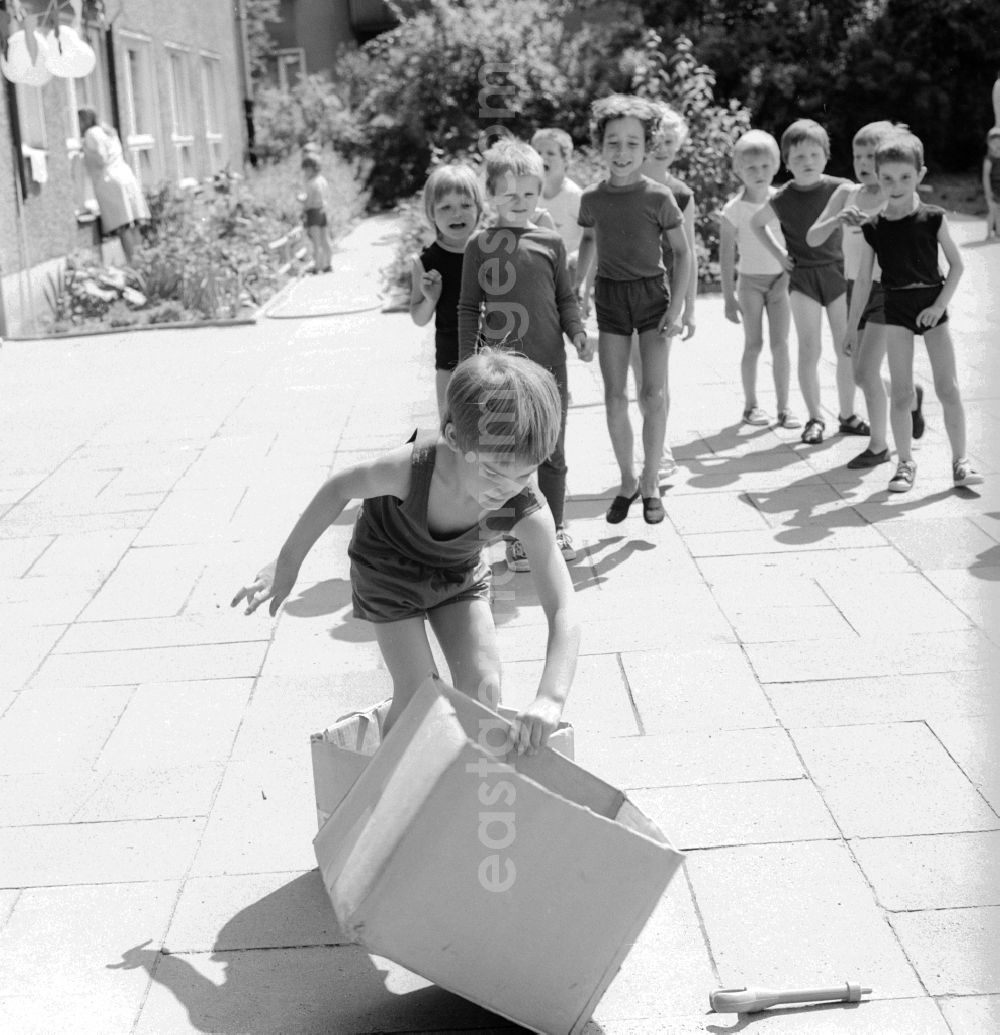 GDR photo archive: Berlin - Children celebrate the International Children's Day at a preschool in Berlin, the former capital of the GDR, German Democratic Republic. On this day there was always a festive program which consisted of sport and play. Here at the box steeplechase