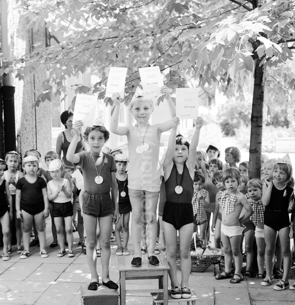 GDR image archive: Berlin - Children celebrate the International Children's Day at a preschool in Berlin, the former capital of the GDR, German Democratic Republic. On this day there was always a festive program which consisted of sport and play. Here is a presentation ceremony