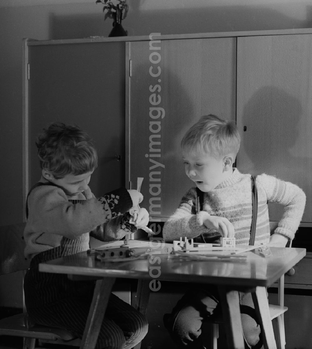 GDR photo archive: Berlin - Friedrichshain - Children in nursery school when playing with a construction kit, to promote fine motor skills, in Berlin - Friedrichshain. The nursery school children in care at the age of four and had to promote the order, the children to school readiness