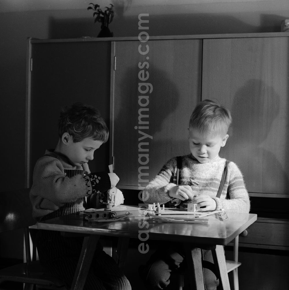 GDR image archive: Berlin - Friedrichshain - Children in nursery school when playing with a construction kit, to promote fine motor skills, in Berlin - Friedrichshain. The nursery school children in care at the age of four and had to promote the order, the children to school readiness