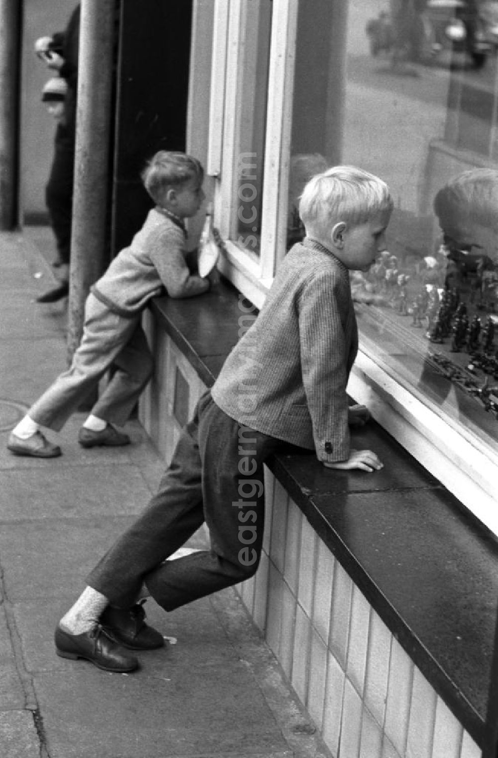 : Dresden 12.6.1962 Zwei Jungs schauen neugierig durch das Schaufenster eines Dresdner Spielwarengeschäftes auf die ausgestellten Spielfiguren.