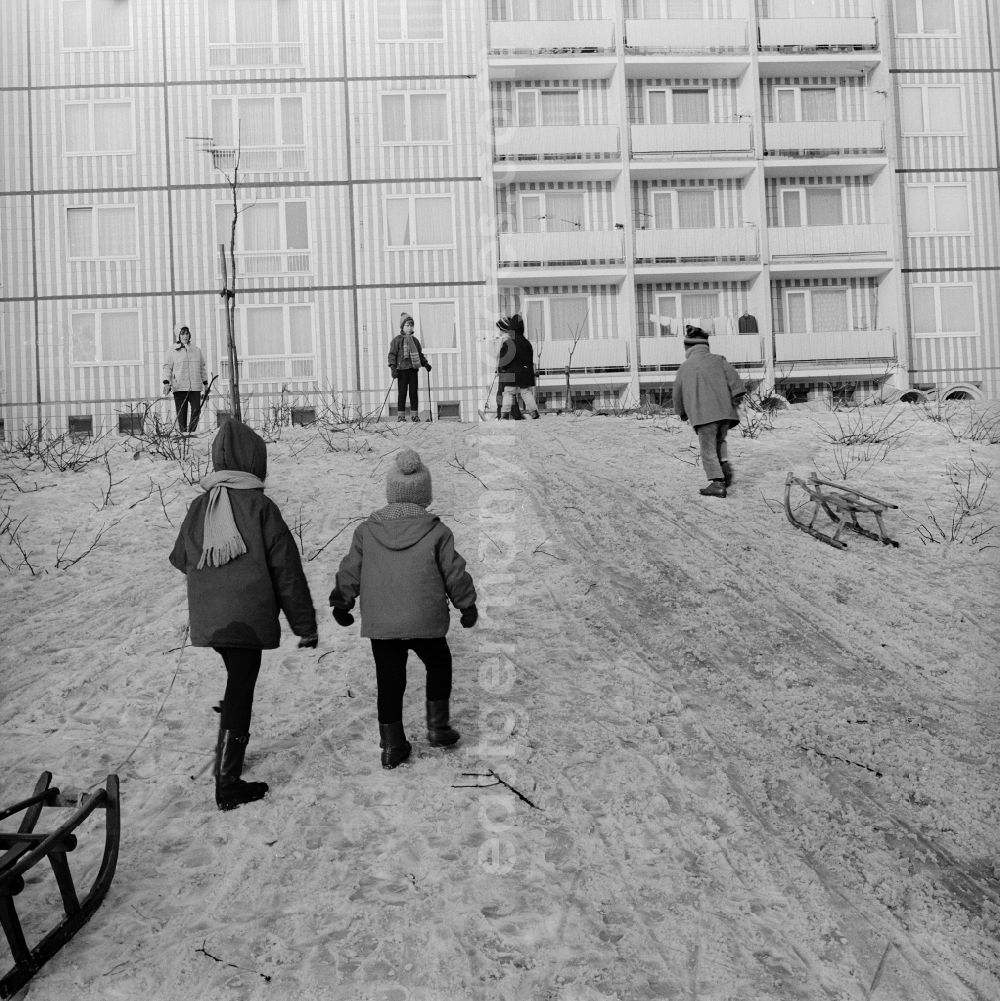 GDR photo archive: Berlin - Children with sledges on a toboggan hill in a residential area in Berlin, the former capital of the GDR, German Democratic Republic