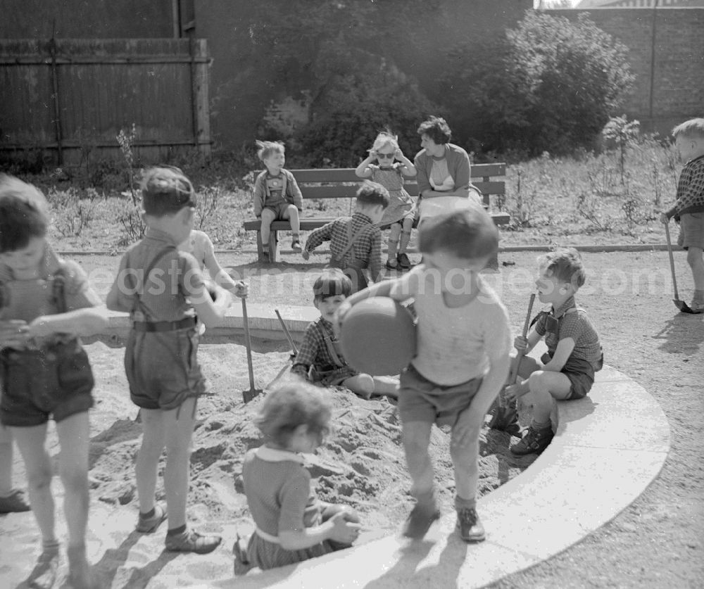 GDR picture archive: Arnstadt - Children play playfully in the bottle box of a kindergarten in Arnstadt in the federal state Thuringia in the area of the former GDR, German democratic republic
