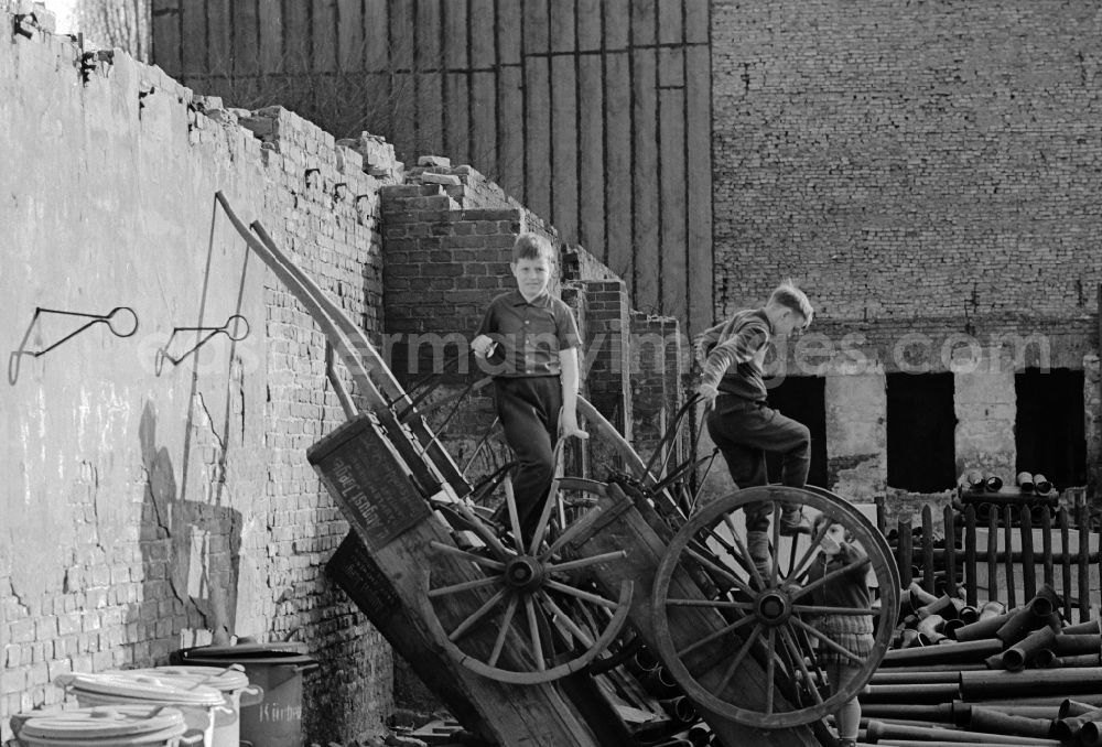 GDR image archive: Berlin - Children playing in a Berlin backyard on old wooden carts in Berlin, the former capital of the GDR, German Democratic Republic