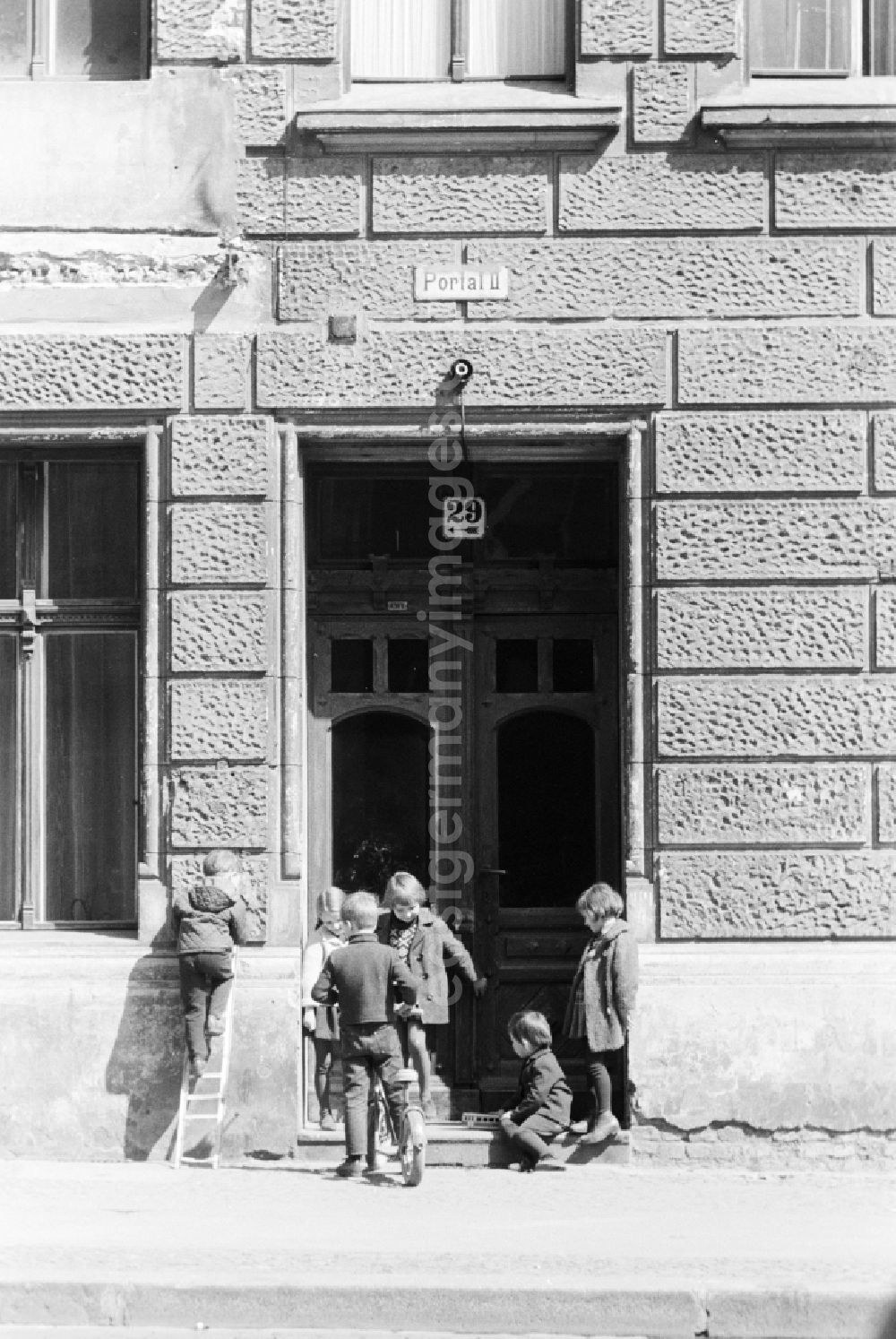 GDR picture archive: Berlin - Children are playing in front of the entrance of an old building in Berlin, the former capital of the GDR, German Democratic Republic