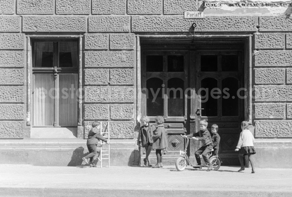 GDR image archive: Berlin - Children are playing in front of the entrance of an old building in Berlin, the former capital of the GDR, German Democratic Republic