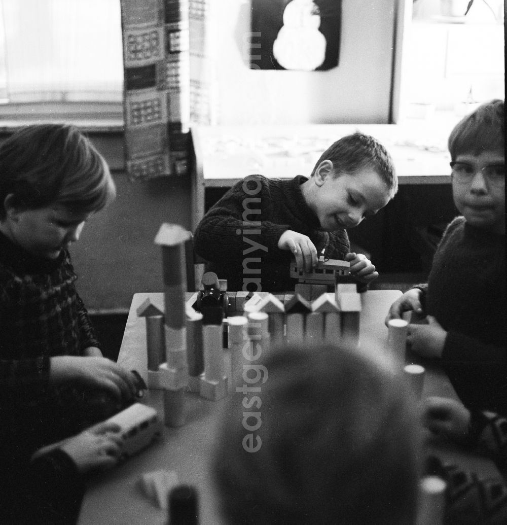 GDR photo archive: Berlin - Kids playing with wooden blocks on a table in Berlin