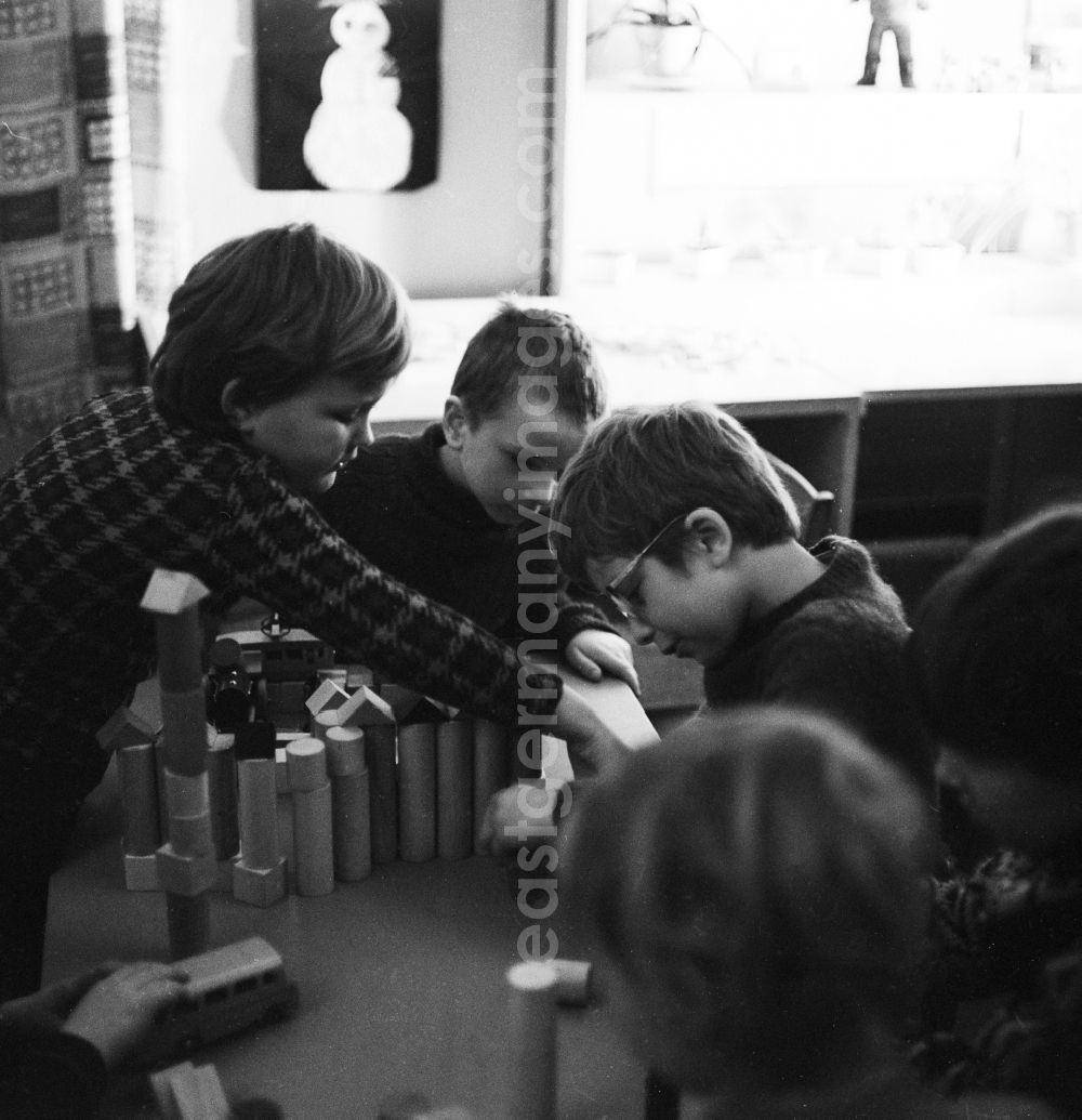 GDR picture archive: Berlin - Kids playing with wooden blocks on a table in Berlin