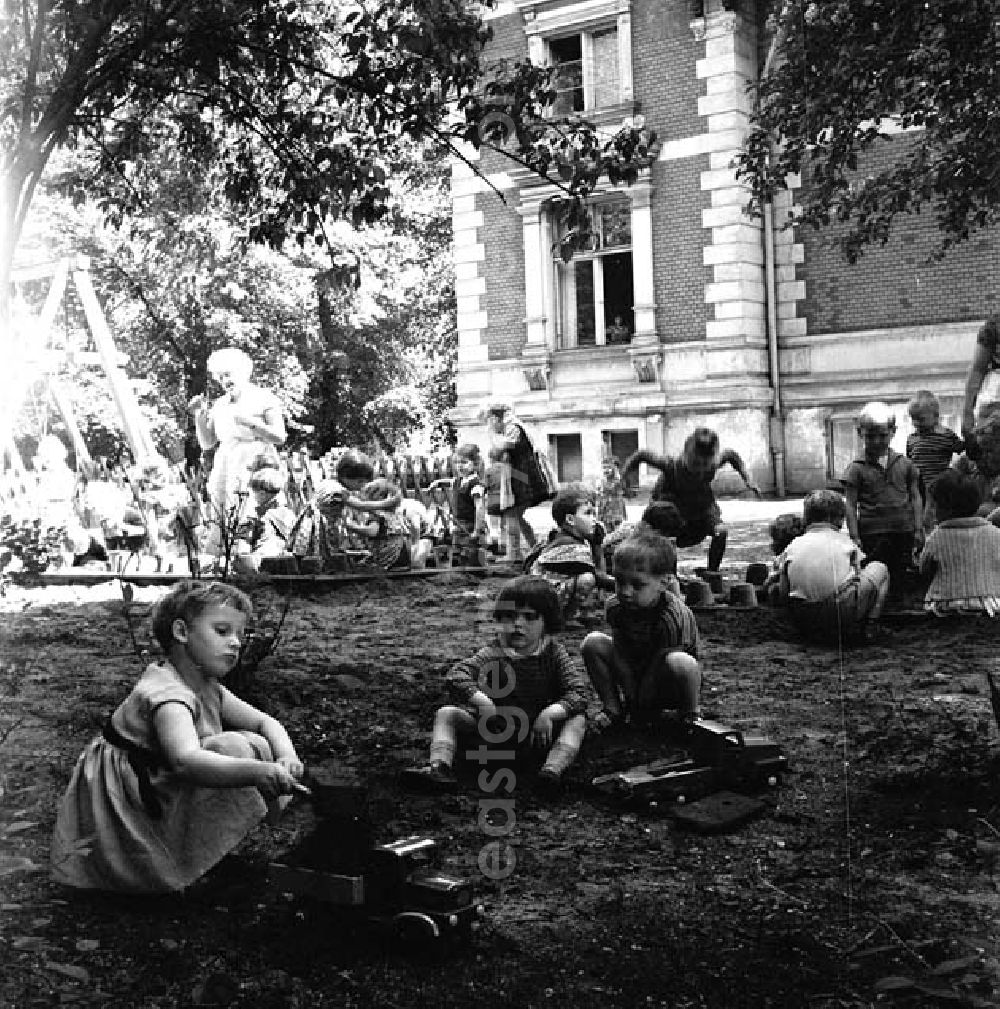GDR photo archive: Brandenburg - Kinder / Kleinkinder spielen im Sandkasten / Buddelkasten auf Kindergarten-Spielplatz.