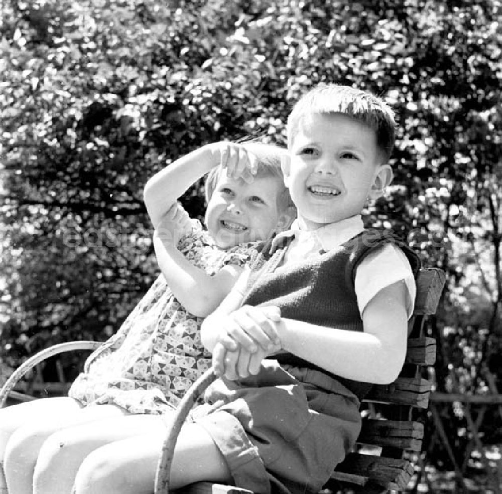 GDR photo archive: Brandenburg - Nah: Zwei Kinder / Kleinkinder sitzen zusammen in Karussell auf Kindergarten-Spielplatz.