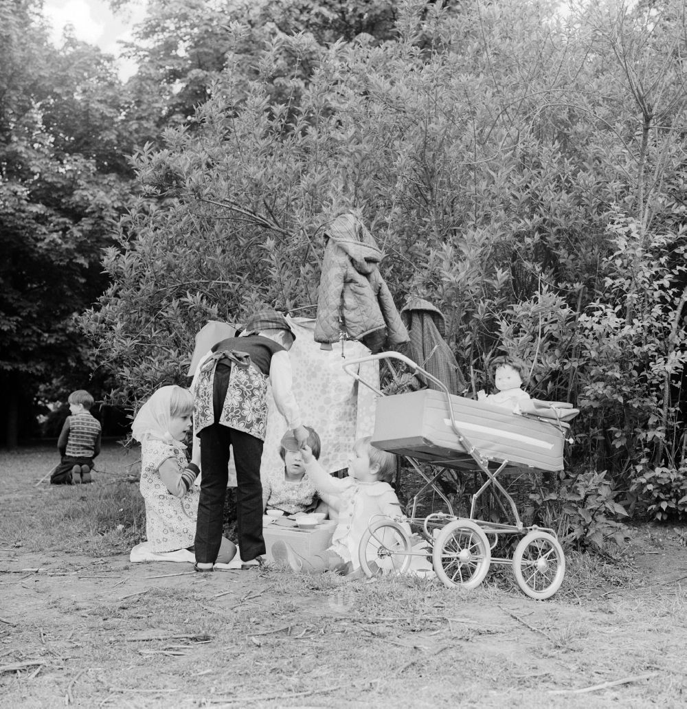 GDR image archive: Berlin - Children playing mother father child in a garden in Berlin, the former capital of the GDR, German Democratic Republic