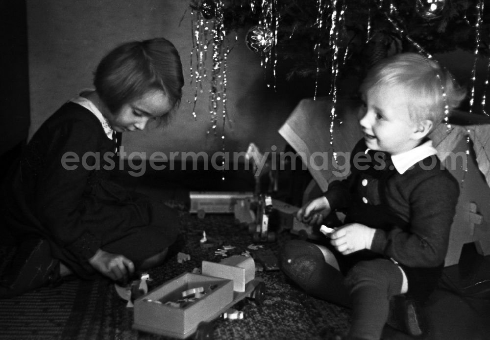GDR image archive: Merseburg - Children stand beaming before the Christmas tree in Merseburg in the federal state Saxony-Anhalt in Germany