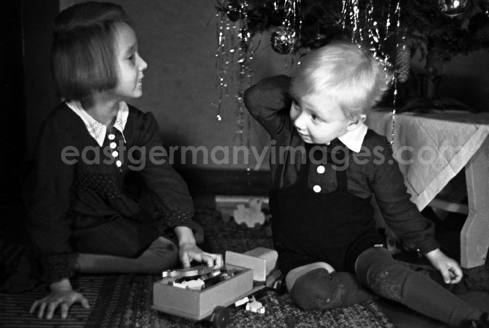 GDR photo archive: Merseburg - Children stand beaming before the Christmas tree in Merseburg in the federal state Saxony-Anhalt in Germany
