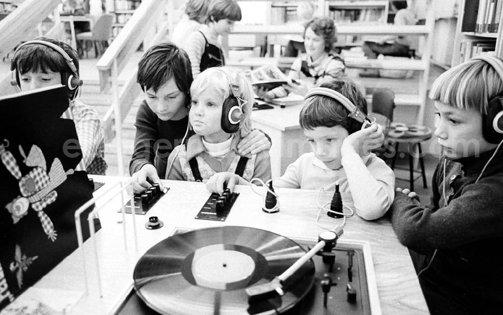GDR image archive: Berlin - Kinder hören sich in einer Kinderbücherei / Bibliothek Langspielplatten / Schallplatten an.