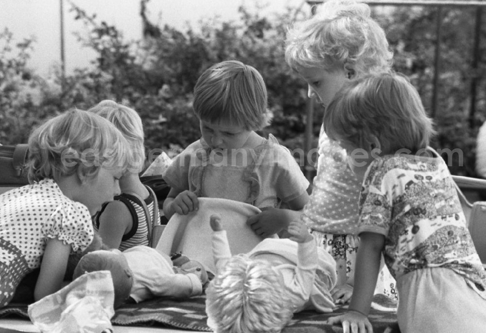 GDR photo archive: Berlin - Girls playing together with dolls in garden from kindergarten in Berlin Eastberlin on the territory of the former GDR, German Democratic Republic