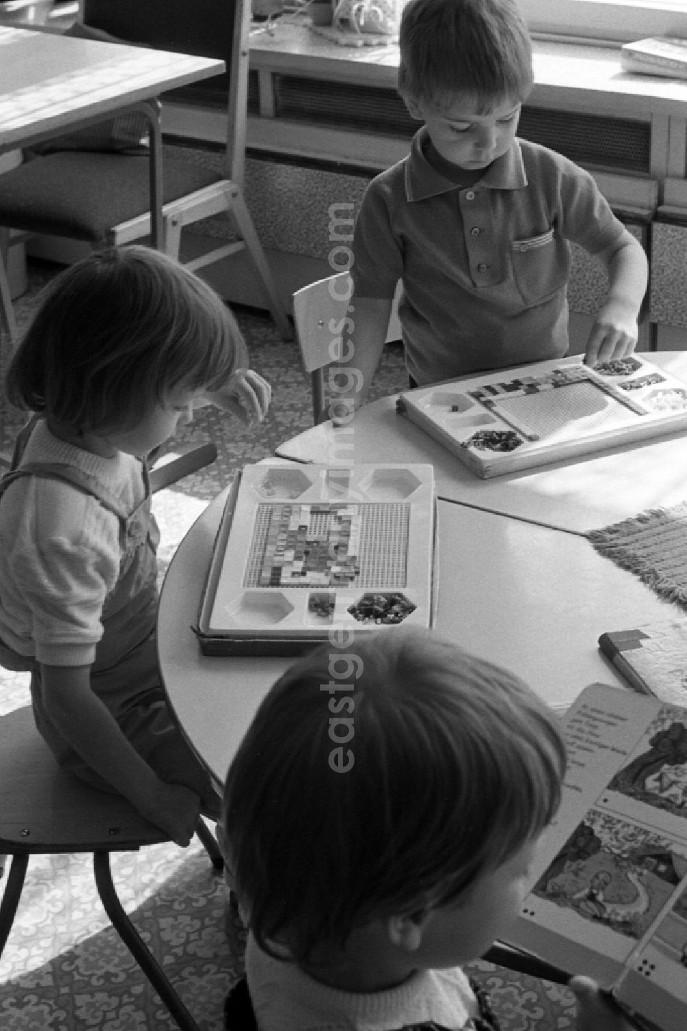 GDR picture archive: Berlin - Children play at the table with a Gloria Mosaic peg game in Berlin Eastberlin on the territory of the former GDR, German Democratic Republic