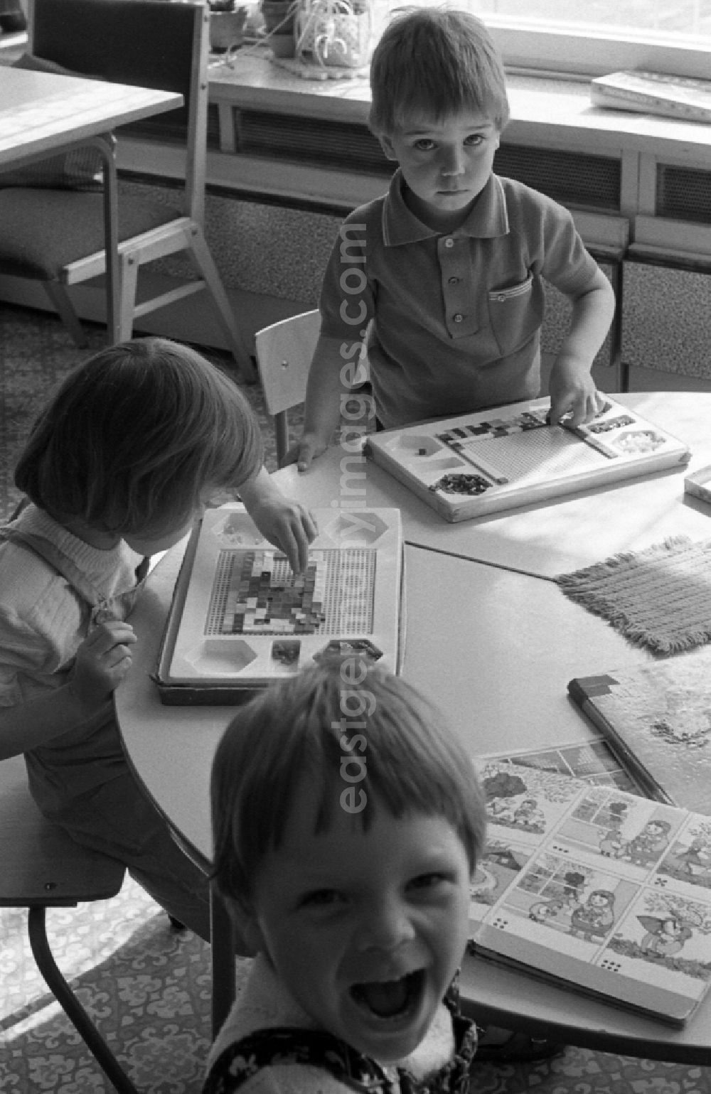 GDR image archive: Berlin - Children play at the table with a Gloria Mosaic peg game in Berlin Eastberlin on the territory of the former GDR, German Democratic Republic