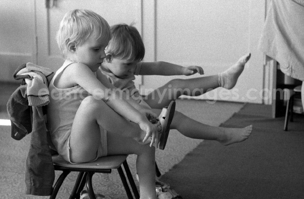 Berlin: Preparing for a nap in the kindergarten in Berlin Eastberlin on the territory of the former GDR, German Democratic Republic. Toddlers take off their clothes together
