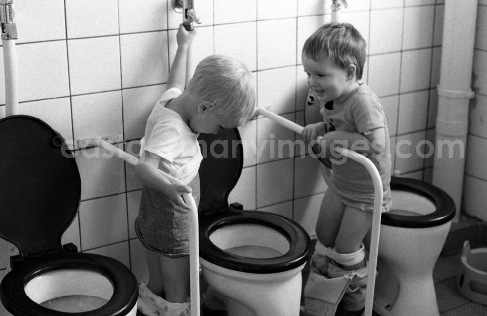 GDR photo archive: Berlin - Toddlers go to the lavatory together in a day nursery in Berlin Eastberlin on the territory of the former GDR, German Democratic Republic