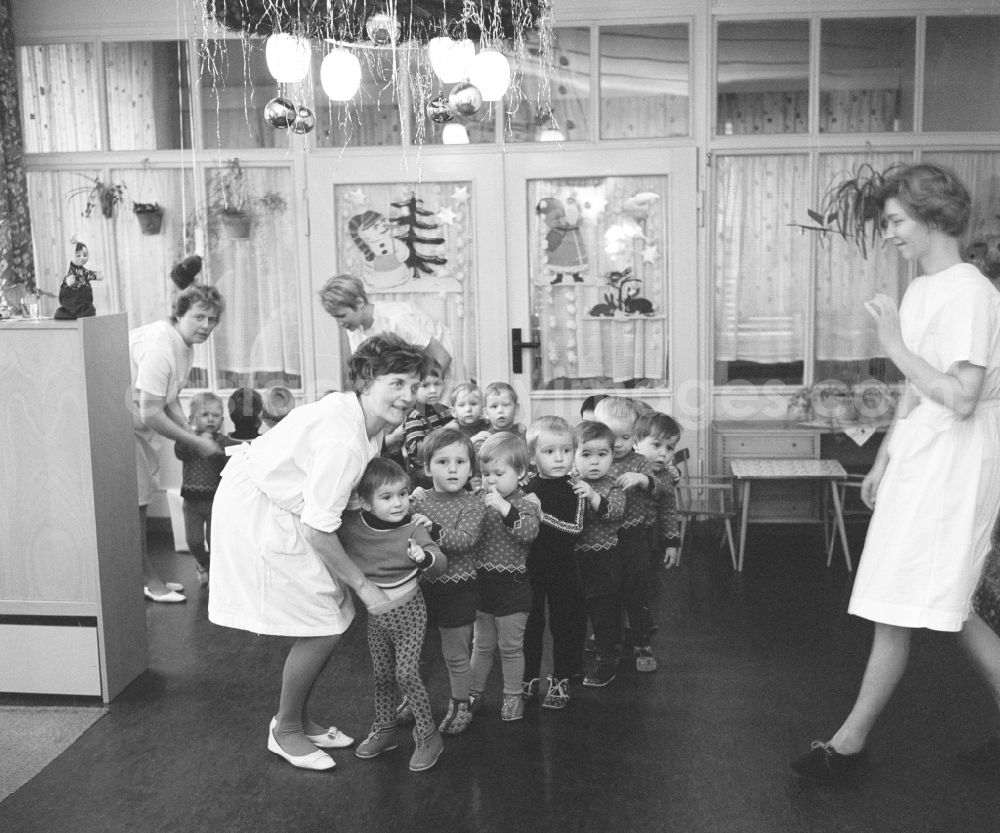 GDR image archive: Silbitz - Everyday life in a baby cot in Silbitz in today s state of Thuringia. Children stand in a row, along with nursery nurse in white coats