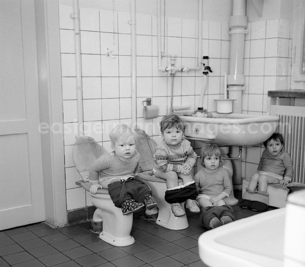 GDR picture archive: Silbitz - Everyday life in a baby cot in Silbitz in today s state of Thuringia. Children sit on the lavatory and the potty