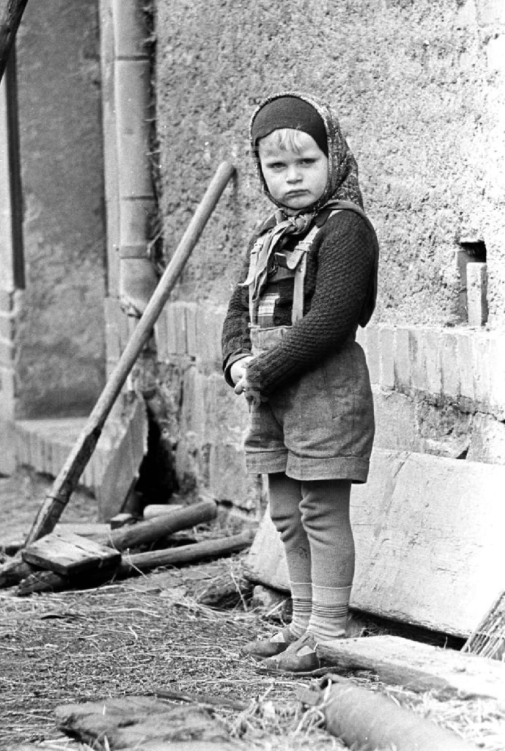 GDR picture archive: Leipzig - Mit dem Kopftuch von Mutti, der Lederhose des großen Bruders und der selbstgestrickten Jacke von Oma ist dieses Mädchen gut geschützt gegen die aufkommende Kälte des Spätherbstes.