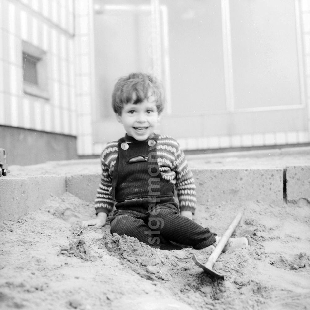 GDR image archive: Berlin - A small boy in a Kordlatzose plays in the sandpit in Berlin, the former capital of the GDR, German democratic republic