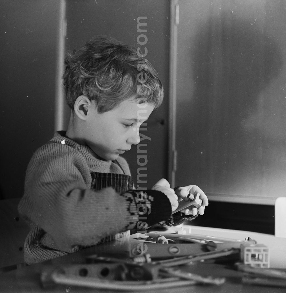 GDR picture archive: Berlin - Friedrichshain - Little child in nursery school when playing with a construction kit, to promote fine motor skills, in Berlin - Friedrichshain. The nursery school children in care at the age of four and had to promote the order, the children to school readiness