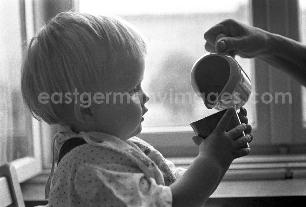 GDR image archive: Berlin - Friedrichshain - A small child while drinking a cup in Berlin