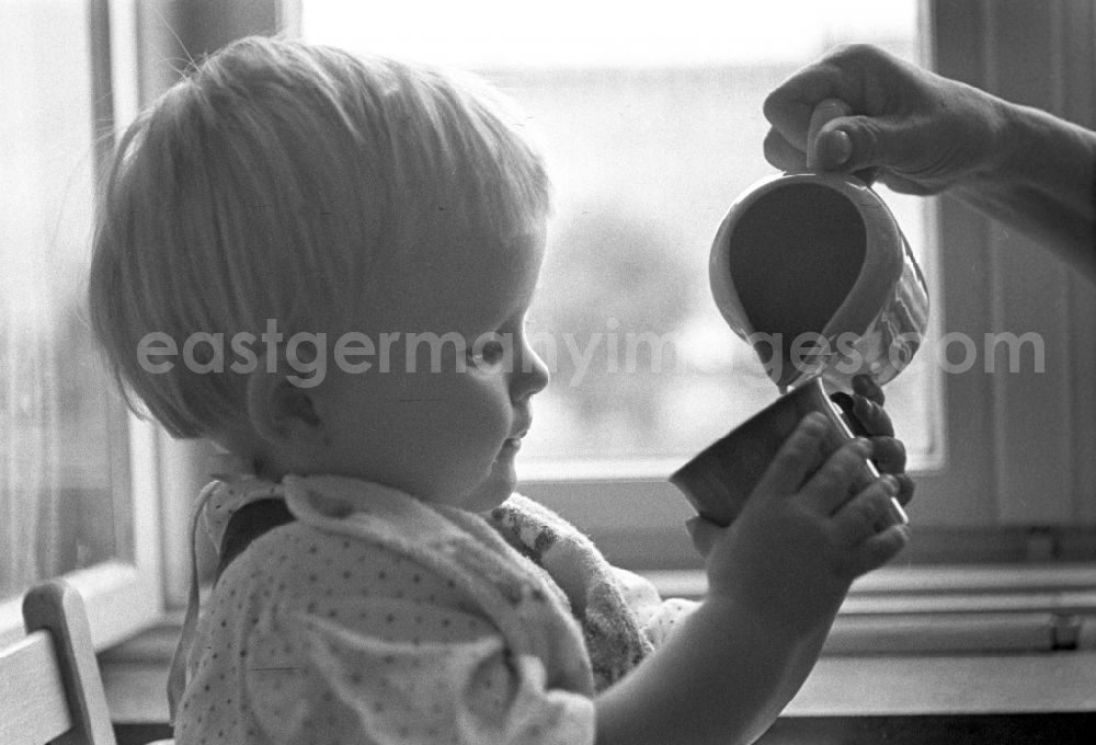 Berlin - Friedrichshain: A small child while drinking a cup in Berlin