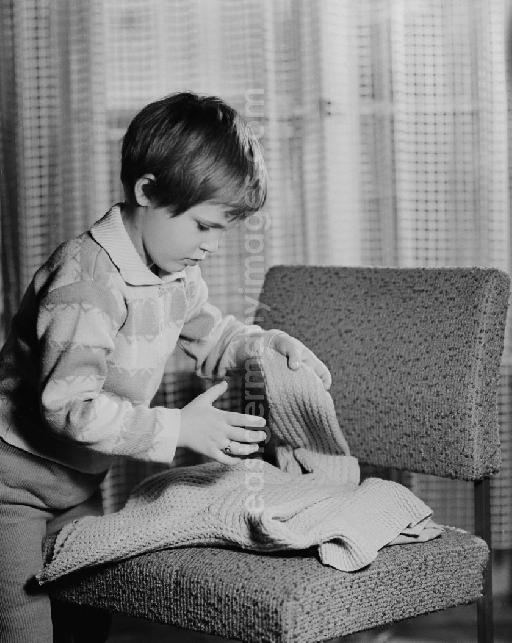 GDR picture archive: Berlin - Small child when put together a sweater in Berlin