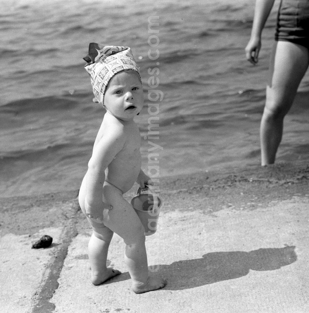 GDR picture archive: Berlin - Köpenick - A small child with bucket on the shore of beach Müggelsee in Berlin - Köpenick.The lido Müggelsee, also known as beach Rahn village is a swimming pool in Berlin-Rahn village on the north bank of the Müggelsee