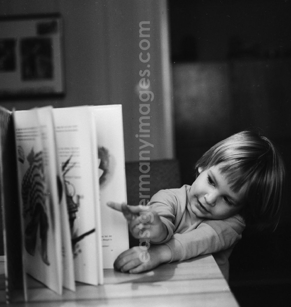 GDR photo archive: Berlin - Small child reading a book in Berlin