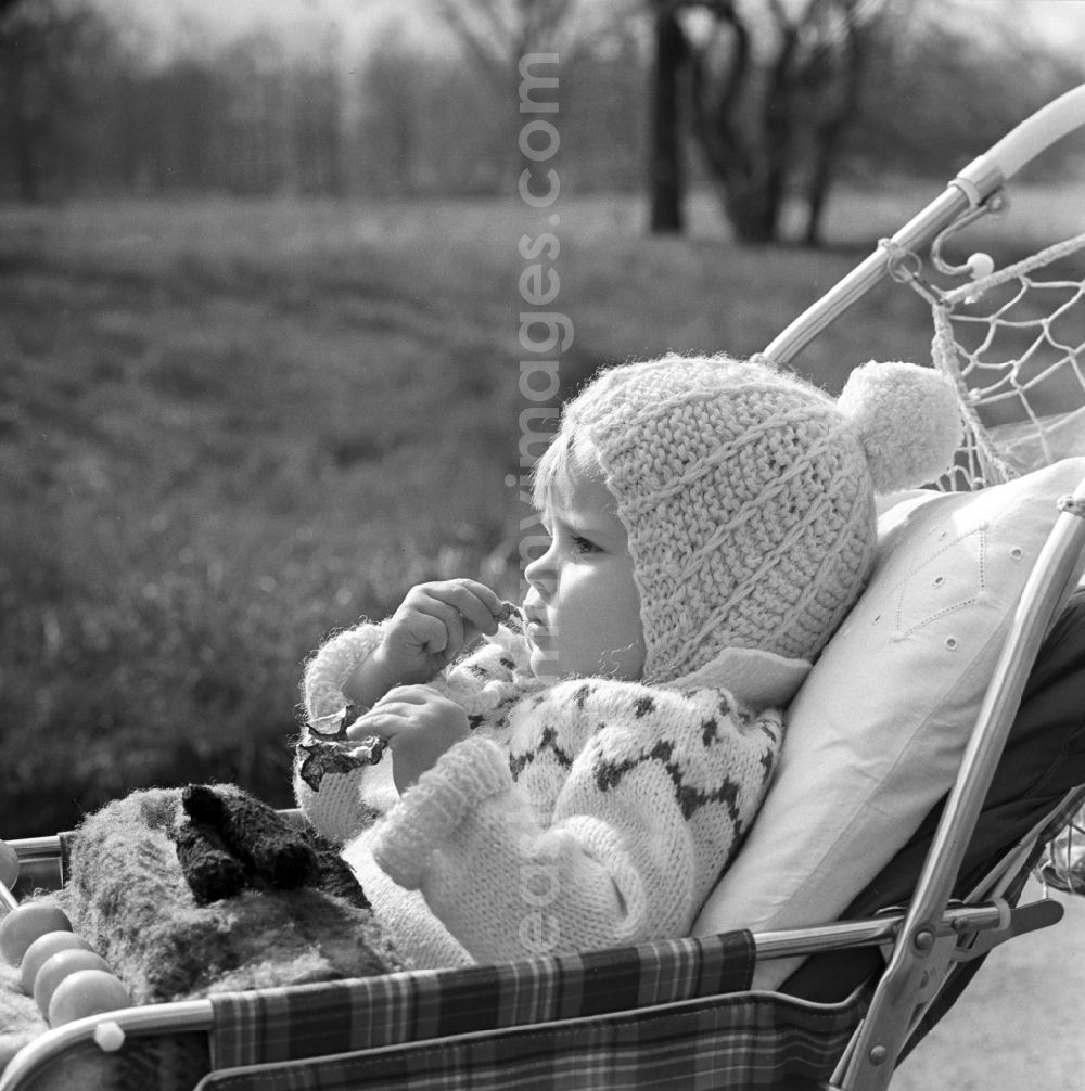 GDR picture archive: Magdeburg - Small child with bobble hat sitting in a pram in Magdeburg