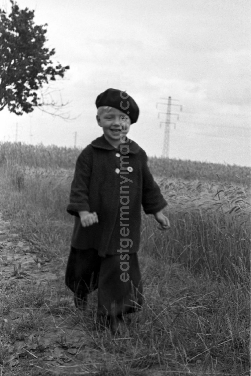 Merseburg: A small child in baggy trousers and with beret runs on a country lane in Merseburg in the federal state Saxony-Anhalt in the area of the former GDR, German democratic republic