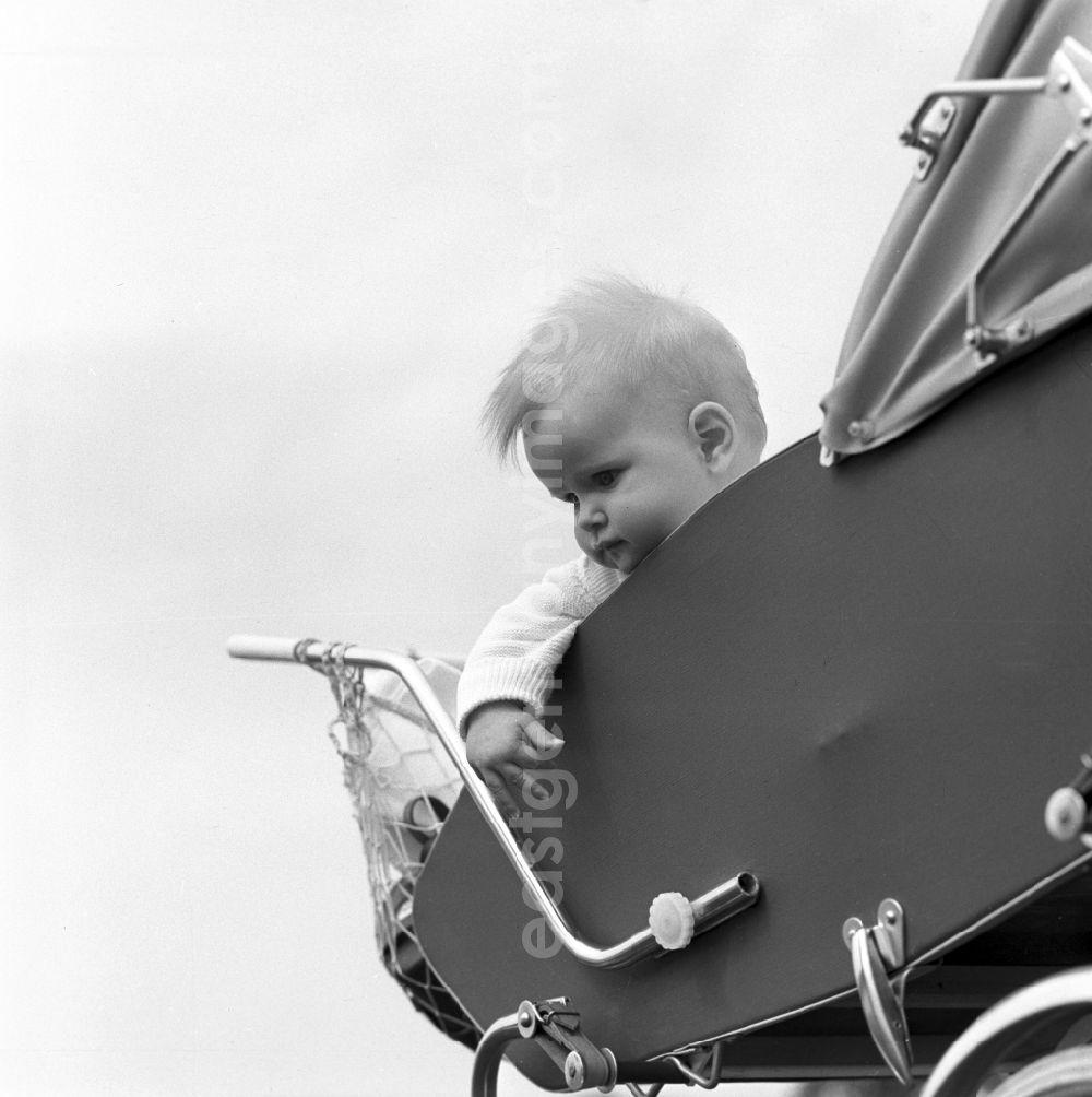 GDR image archive: Magdeburg - A small child is sitting in a stroller and laughs in Magdeburg in Saxony - Anhalt